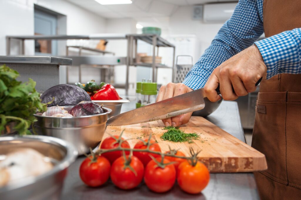 The chef in brown apron cooking in a restaurant kitchen